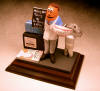 Dentist statue complete with his fish aquarium, picture on "faux" magazine cover, and logo of workplace on his desk